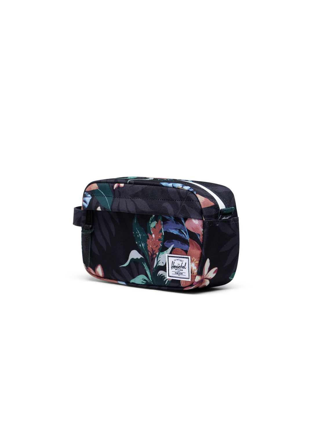 The Herschel Chapter Carry-On Travel Kit is a compact, rectangular toiletry bag with a dark background and colorful floral print, waterproof zipper, front white label, and handy side handle.
