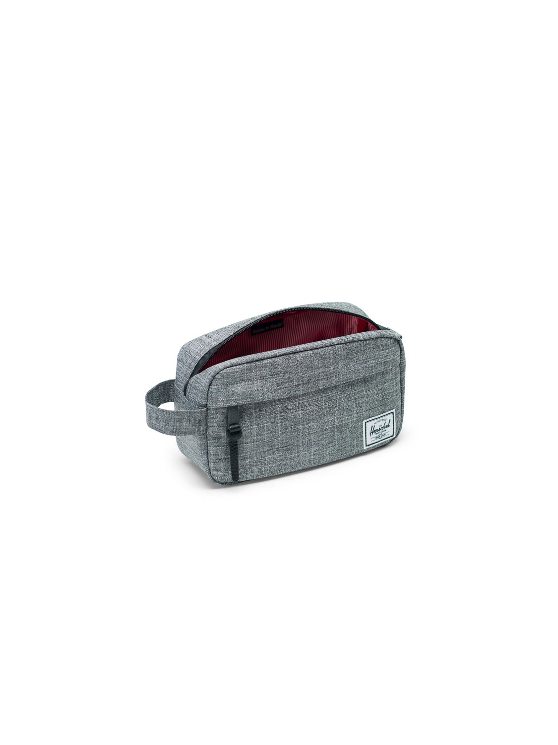 The Herschel Chapter Carry-On Travel Kit is a gray fabric bag with a side handle, front waterproof-zip pocket, open main compartment with red-striped lining, and white logo patch—ideal for travel essentials.