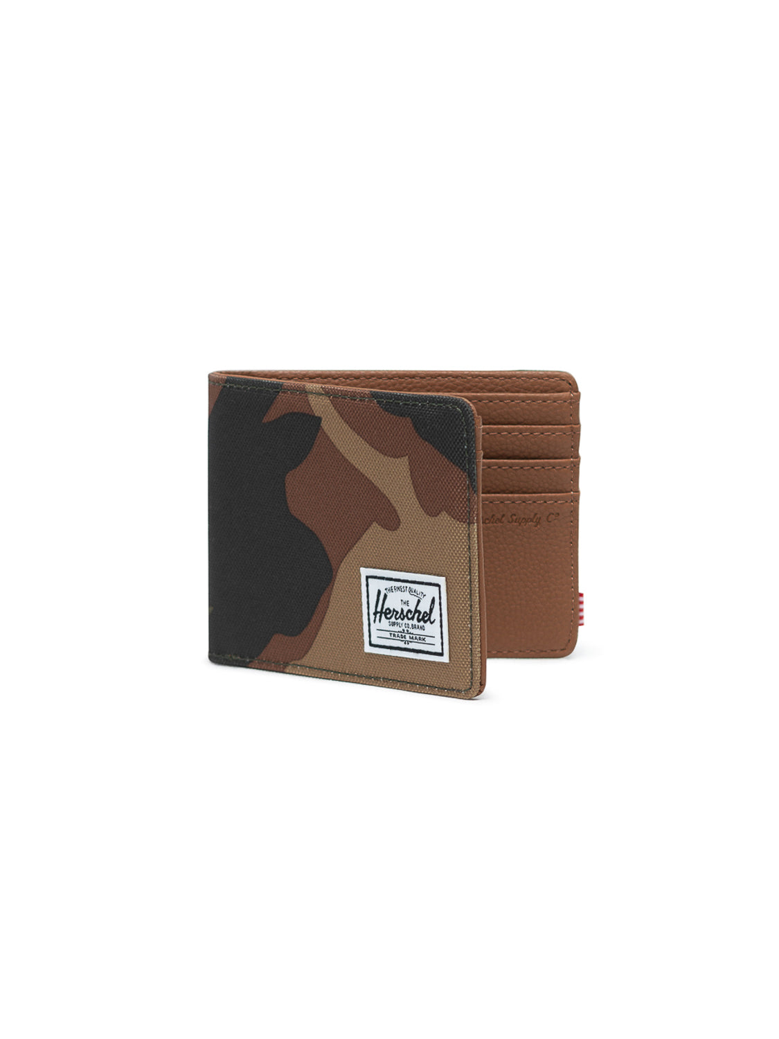 The Herschel Hank Bi-Fold Wallet features a brown and green camouflage pattern with RFID blocking, a white Herschel label on the front, brown interior with multiple card slots, all shown on a white background.