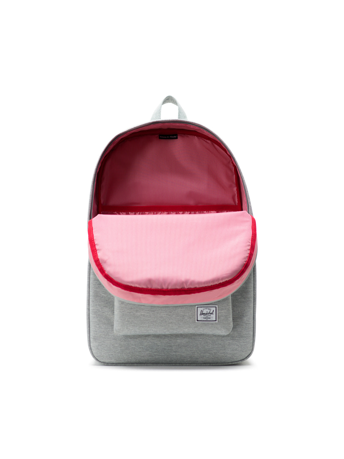 The Herschel Heritage Backpack in light gray is shown open, displaying a pink and white striped lining and a laptop sleeve. It features a small rectangular logo patch on the front pocket, combining classic mountaineering style with practicality.