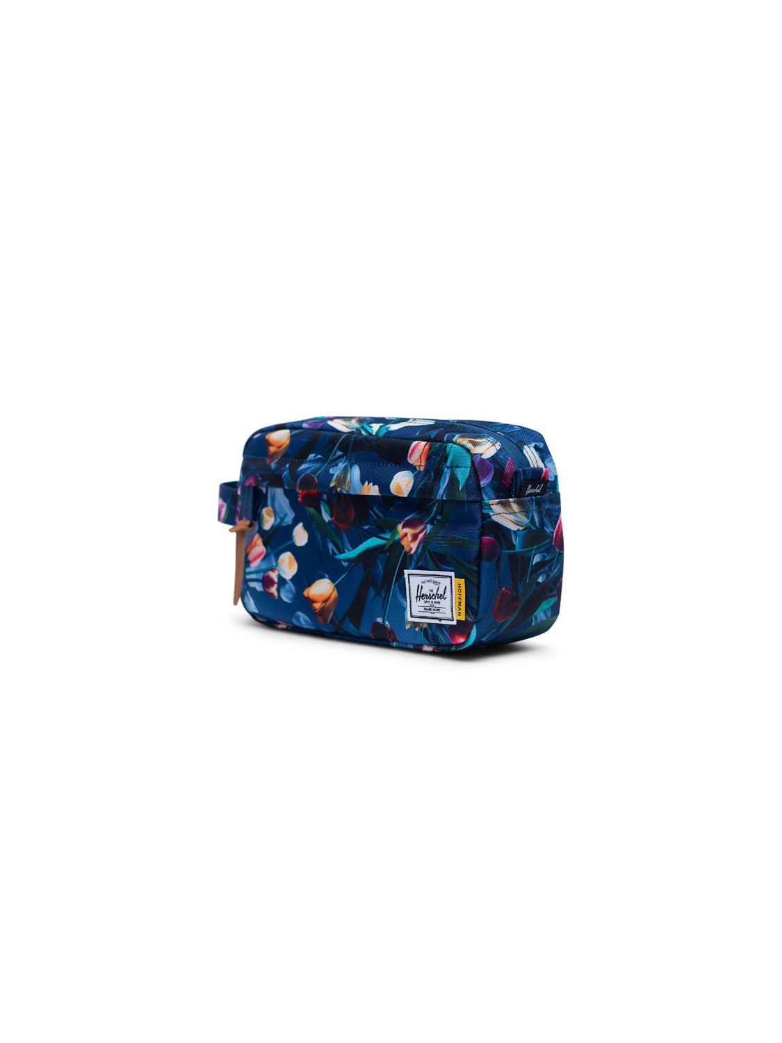 The Herschel Chapter Carry-On Travel Kit is a rectangular toiletry bag with a blue floral pattern, brown pull, waterproof zipper, and white Herschel label on the front. Ideal for compact travel, shown on a plain white background.