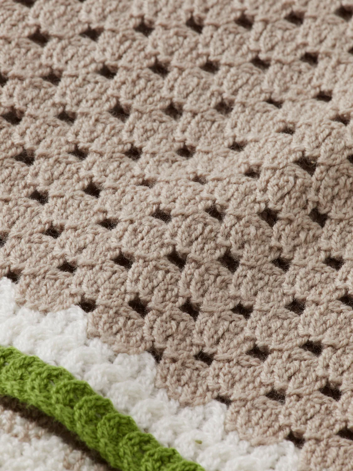 Close-up of the SCOTCH AND SODA Crochet Long Sleeve Shirt 180084 SU25, showcasing a beige textured crochet pattern with white and green details at the edge—a stylish inspiration for unique, artistic fashion statements.