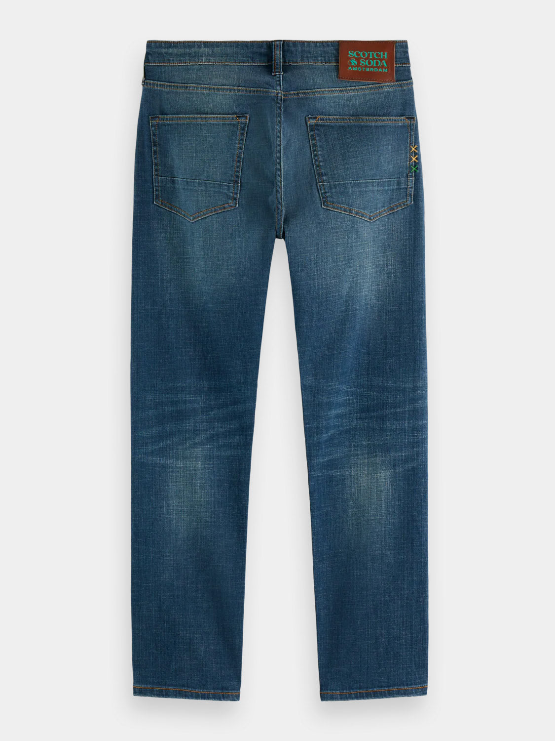 The 180872 Ralston Regular Slim Denim jeans by Scotch & Soda are shown from the back, featuring two rear pockets, faded details, and a brown leather brand patch on the medium-rise waistband.