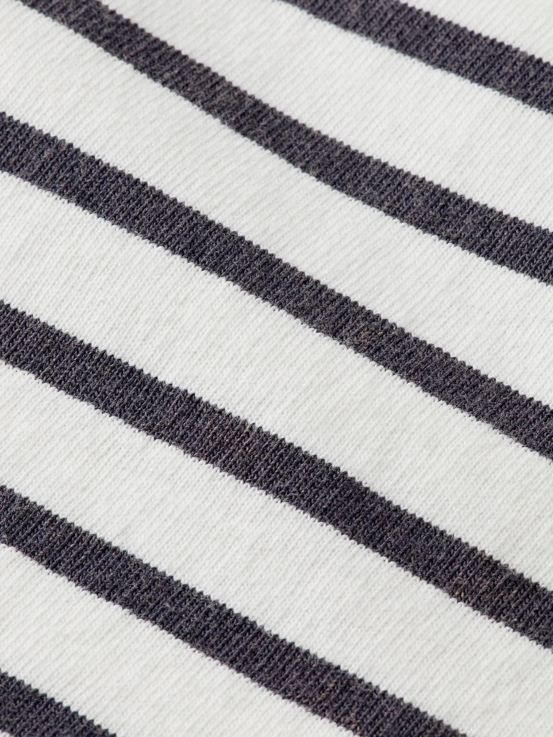 Close-up of Scotch & Soda’s 180878 Denim Washed Long Sleeve Breton Tee, featuring evenly spaced horizontal black stripes on a white knit, with soft texture and regular-fit comfort reminiscent of classic breton style.