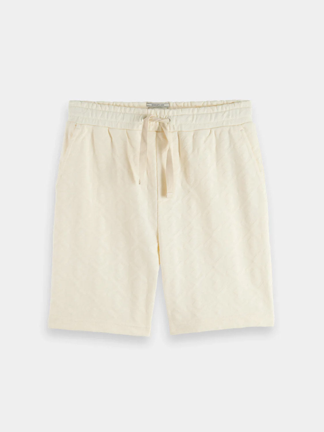 The 181210 Jacquard Terry Sweatshorts by Scotch & Soda feature an off-white jacquard design, elastic waistband, drawstring tie, and side pockets, shown laid flat on a light background.