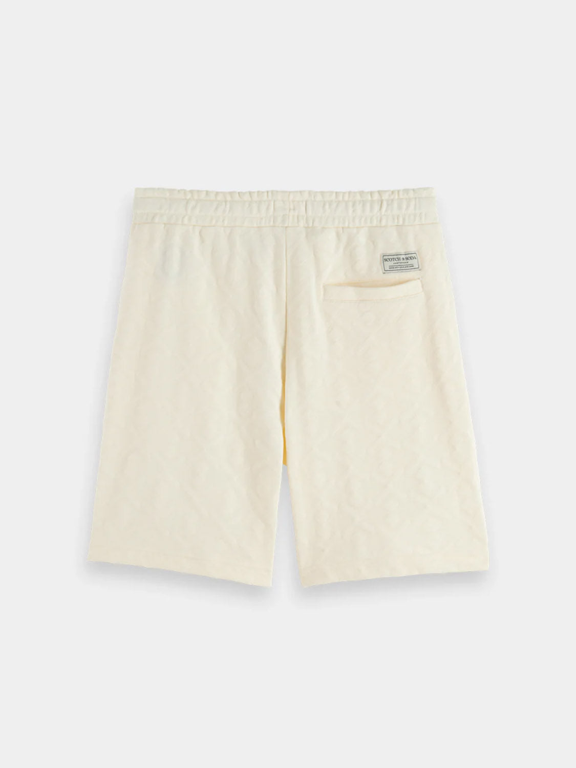 The Scotch & Soda 181210 Jacquard Terry Sweatshorts are cream-colored with a relaxed fit, elastic waistband, right back pocket, and a small rectangular label above the pocket, shown on a plain white background.