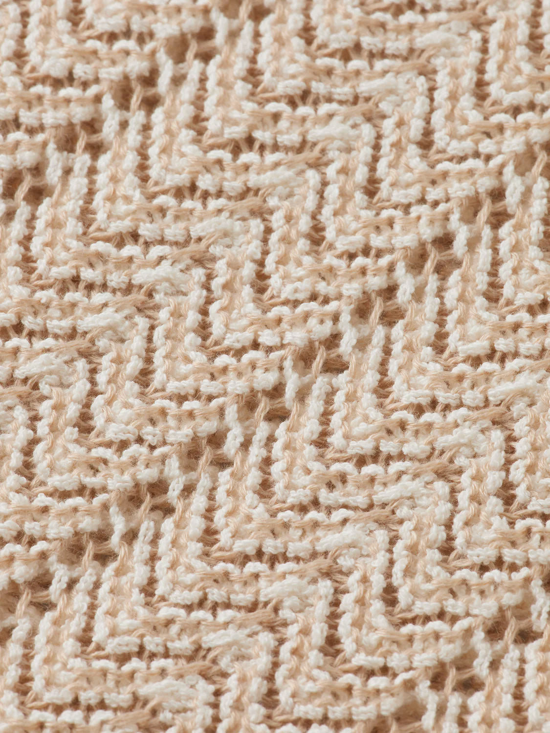 Close-up of the 181322 Open Structured Knitted V-Neck Polo by Scotch & Soda, featuring beige and cream zigzag herringbone patterns with textured stitches in soft, lightweight yarn.