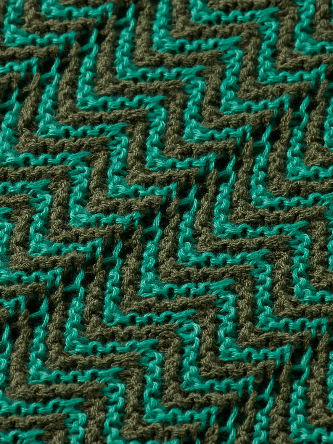 Close-up of the 181322 Open Structured Knitted V-Neck Polo by Scotch & Soda, featuring a lightweight knit with zigzag patterns in alternating teal and dark green for a modern textured look.