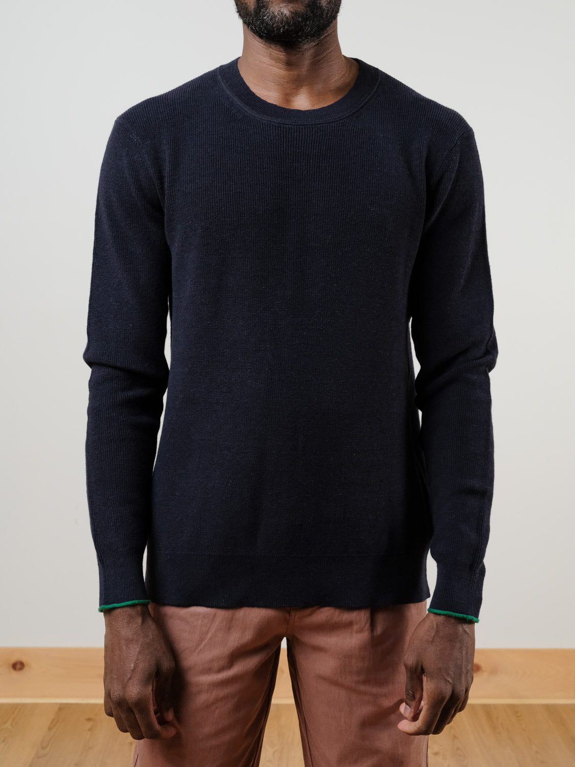 A man wears the SCOTCH AND SODA Linen Blend Crew Neck in navy with light brown pants, standing against a plain background. His hands are relaxed at his sides, and his face is partially out of frame.