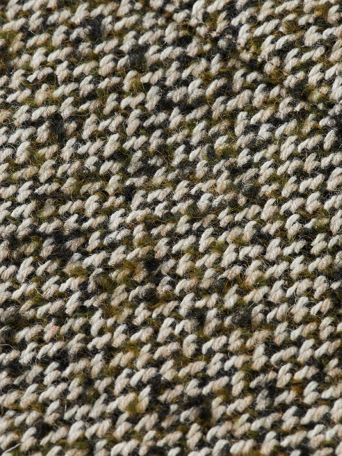 Close-up of the 181609 Multicolored Tweed Overshirt by Scotch & Soda, featuring interlaced beige, green, and black yarns with a detailed, slightly rough texture typical of classic tweed.