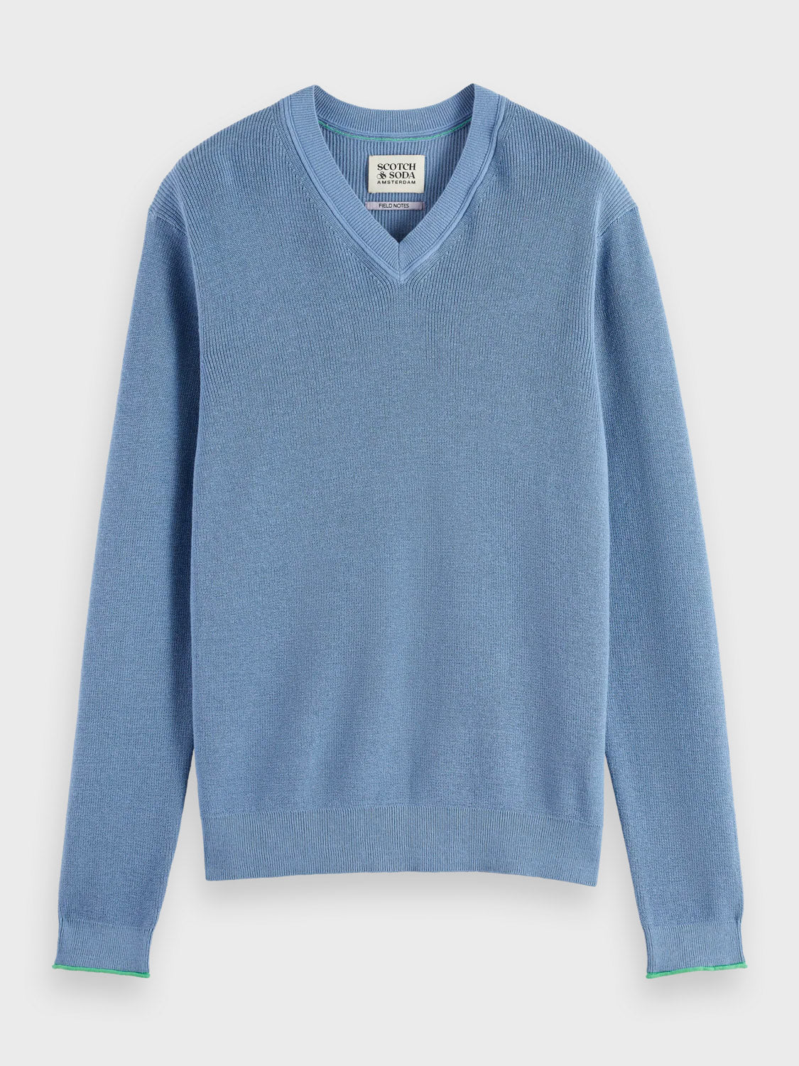 The Scotch & Soda 181773 Cotton Linen V-Neck Pullover, in light blue with long sleeves and ribbed cuffs and hem, is shown on a white background. A white tag is sewn inside the collar—ideal for layering over printed swim shorts.