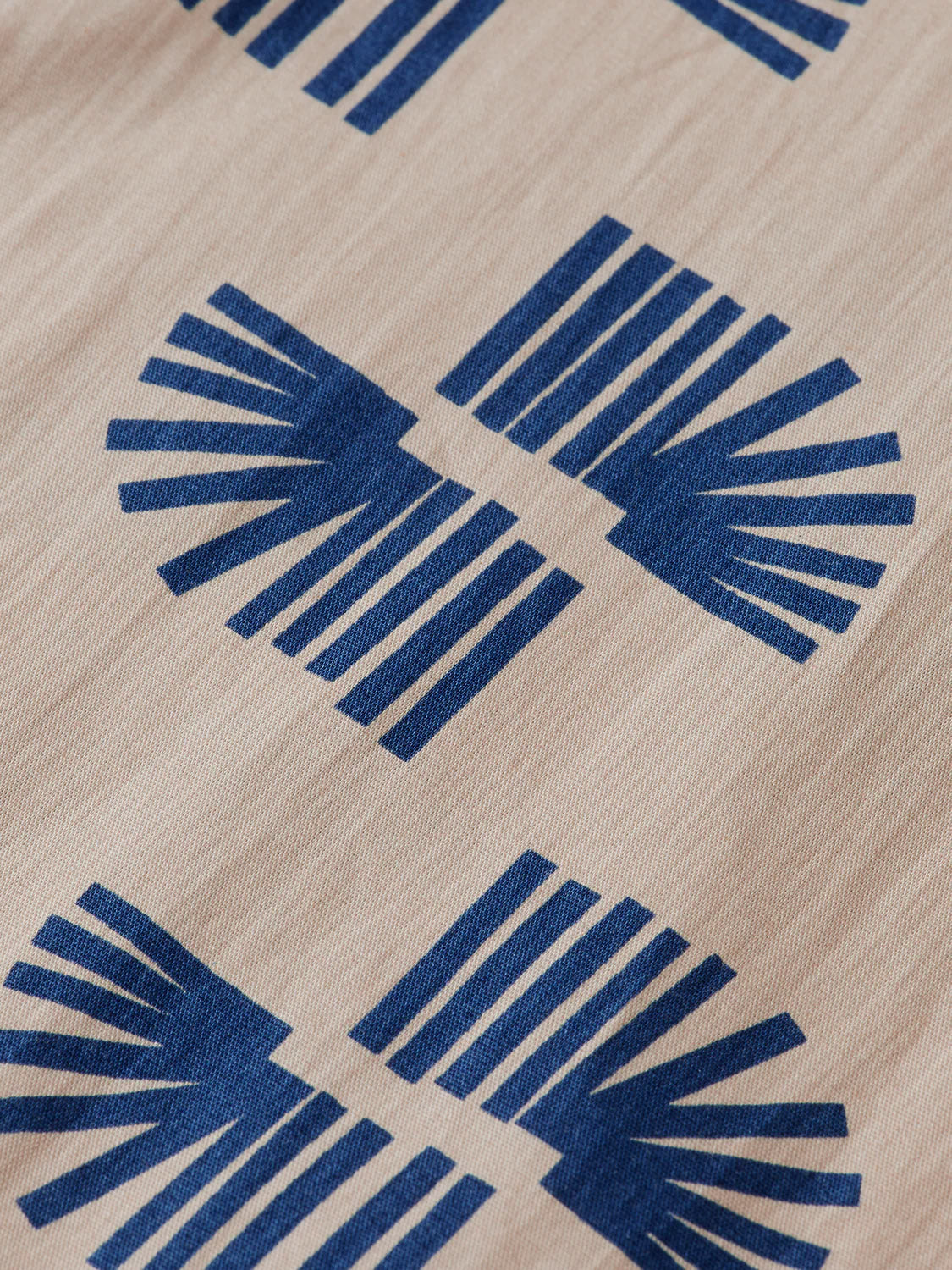 Close-up of the Scotch & Soda 181804 Slim Fit Micro All-Over Printed Shirt, crafted from 100% cotton beige fabric with a blue geometric pattern—ideal for a modern, slim-fit style.