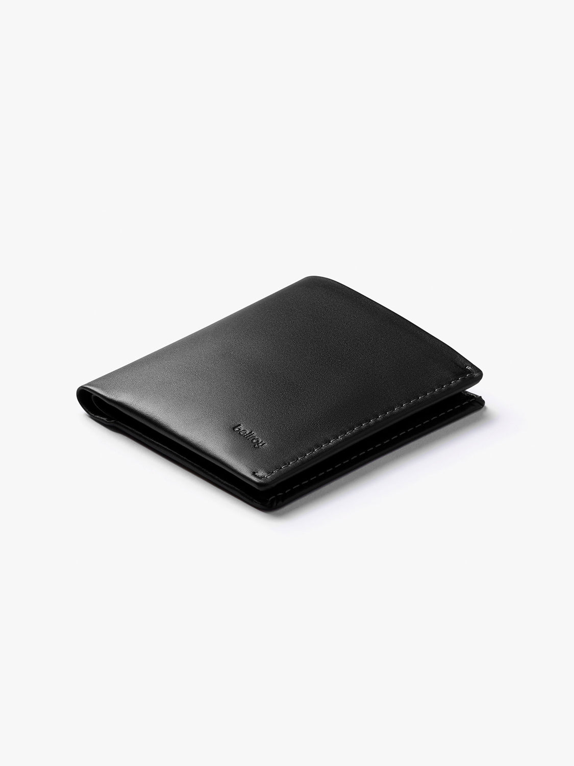 The Bellroy Note Sleeve Wallet—a black leather slim wallet with minimal stitching and a smooth finish—is shown closed on a plain white background.
