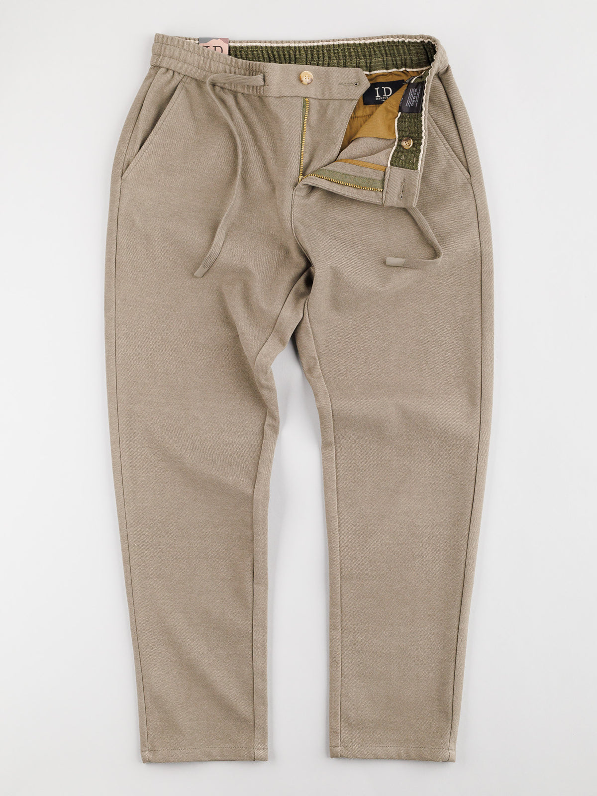 A pair of beige Brighton Brushed Polyester Rayon Pants from ID Menswear shown on a neutral background. They boast a button and zipper fly, angled front pockets, visible waistband with belt loops, and contrasting inner lining.