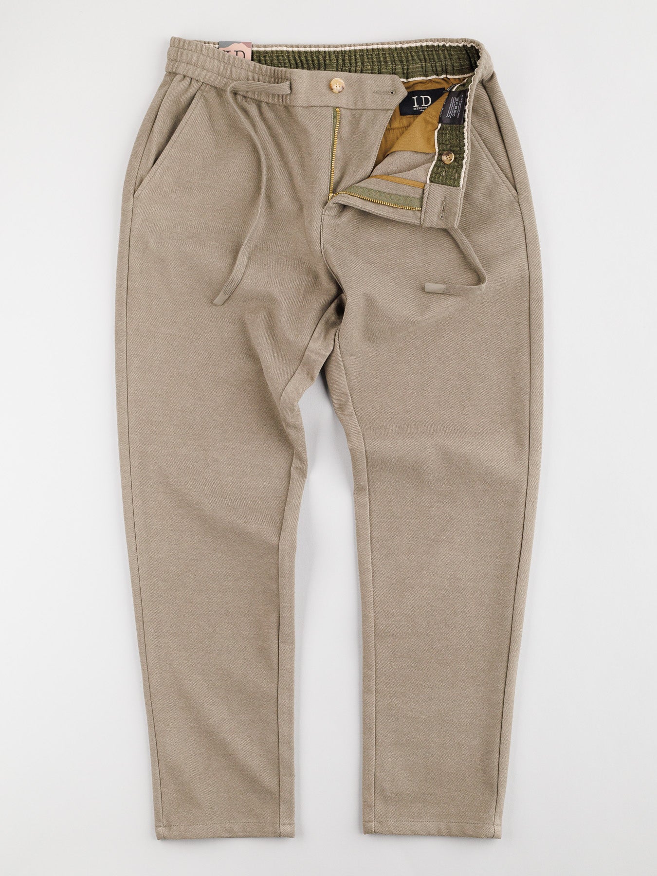 A pair of beige Brighton Brushed Polyester Rayon Pants from ID Menswear shown on a neutral background. They boast a button and zipper fly, angled front pockets, visible waistband with belt loops, and contrasting inner lining.