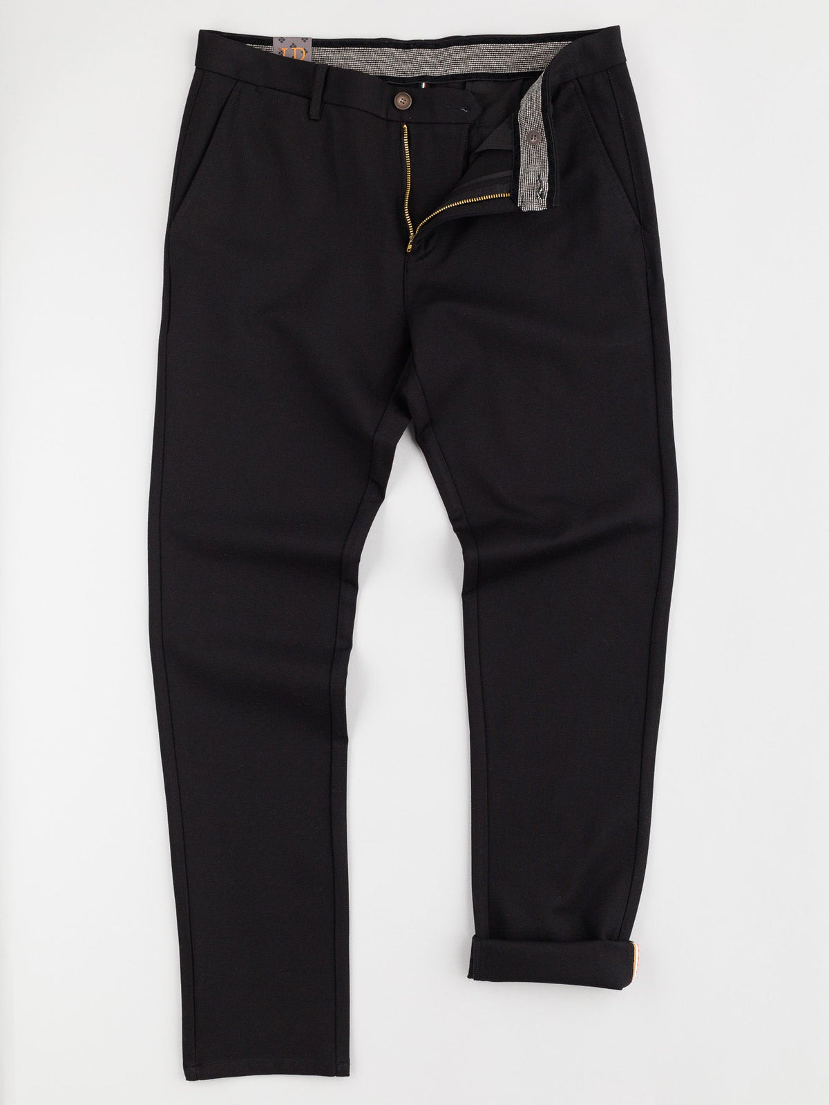 The Montrose 4-Way Stretch Dress Pant by ID Menswear features a slim fit, black color, rolled-up right cuff, front zipper and button closure, and side pockets. Laid flat on a white surface—ideal for a business casual look.