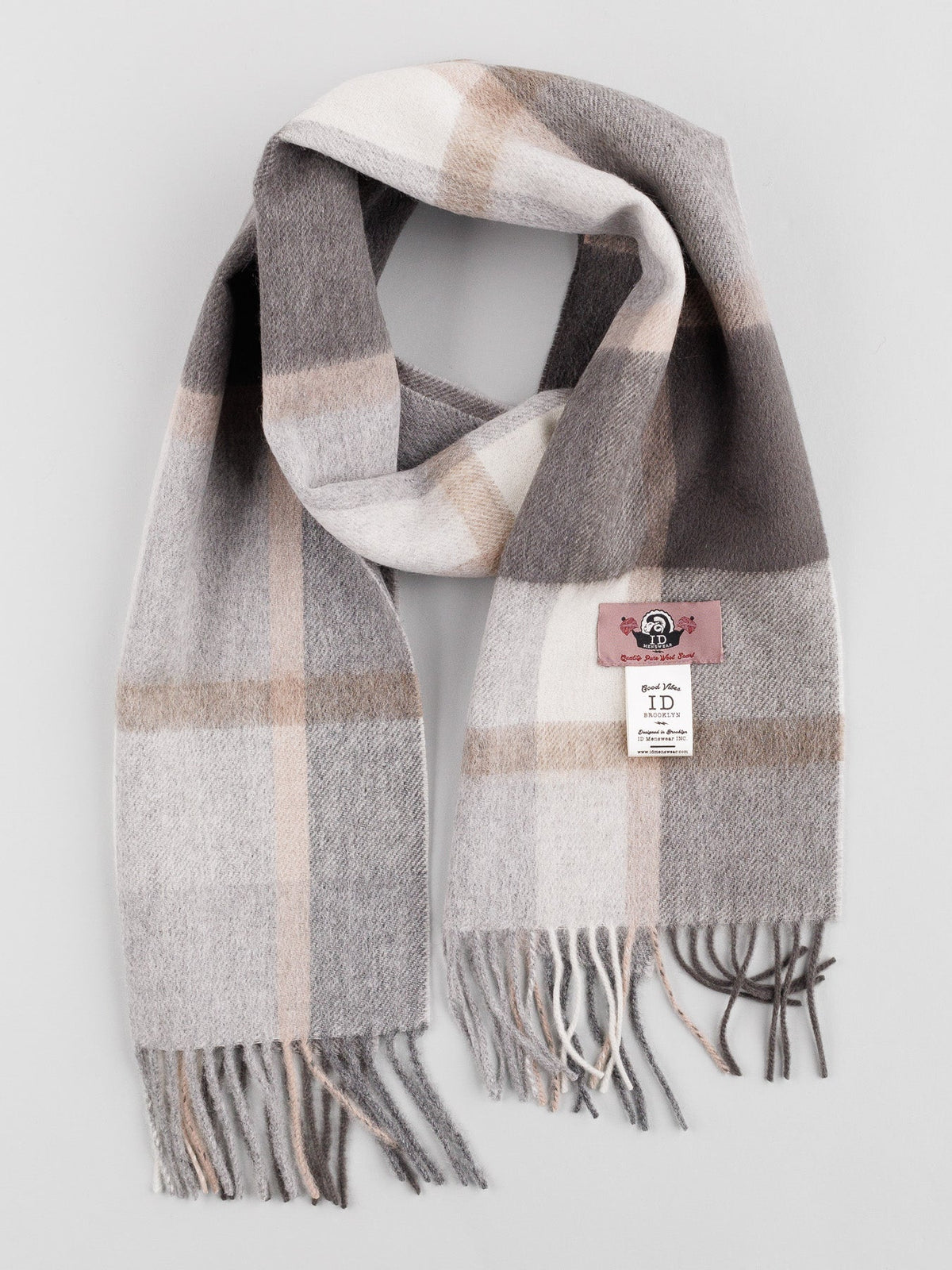 The Wool Timeless Checked Scarf by ID Menswear features a plaid pattern in gray, beige, and white with self-fringed ends. Its folded design showcases brand and material labels against a light gray background.