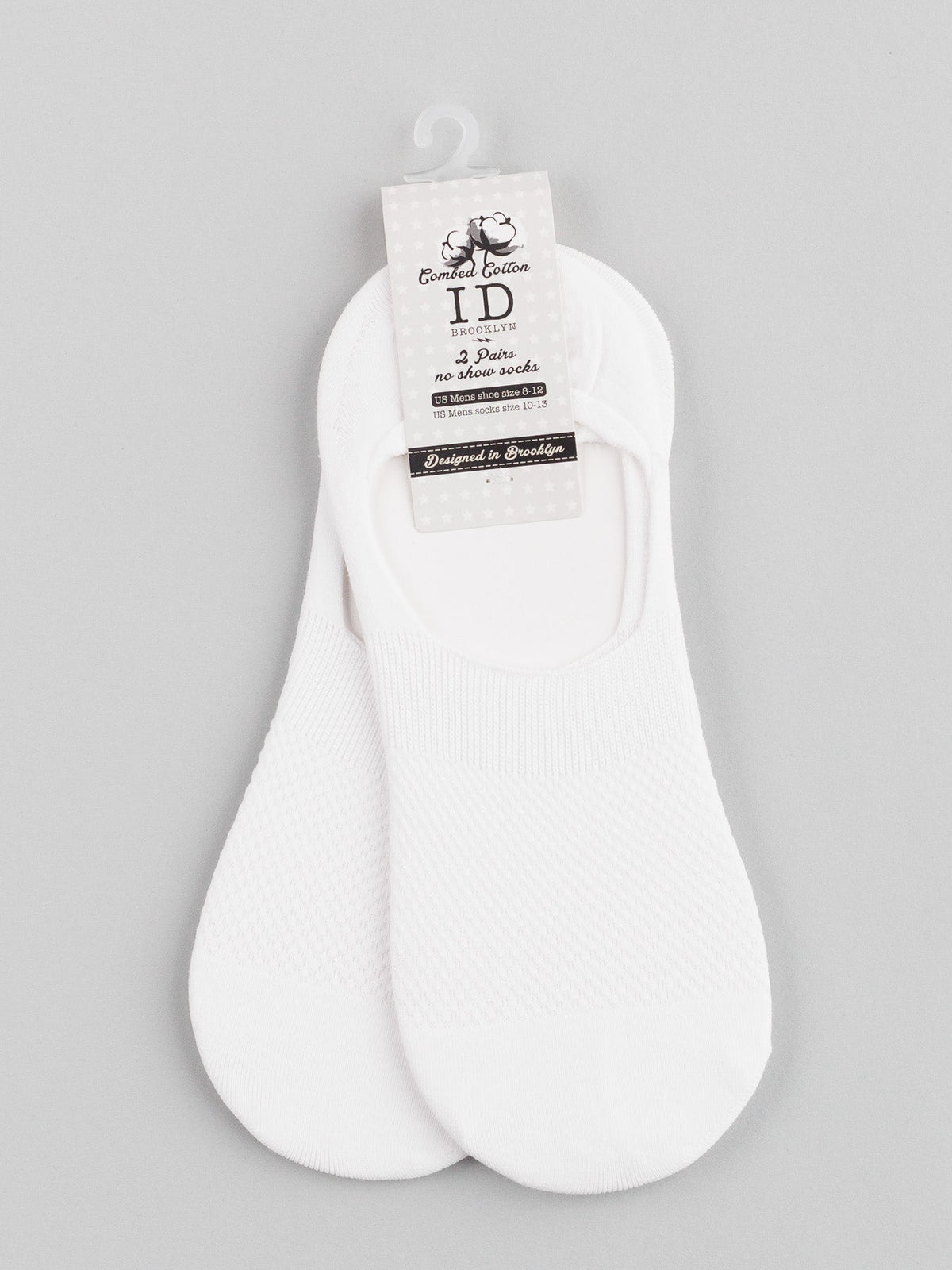 Against a gray background, the Essential Edition label features ID Menswears M1 No Show Socks, a white pair made from soft combed cotton for unrivaled comfort. Available in size 3-8 for women, these socks are perfect everyday essentials that remain invisible with low-cut shoes.