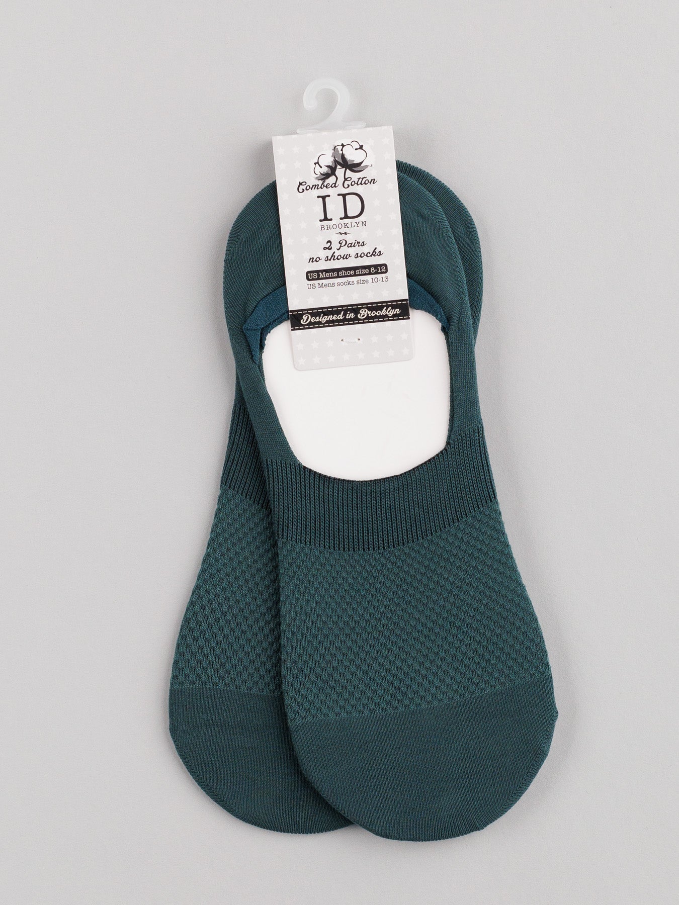 The ID Menswear M1 No Show Socks, made from soft combed cotton, boast a dark teal textured pattern. Ideal for low-cut shoes, they are attractively displayed on a white cardboard hanger with product details on a light gray background.