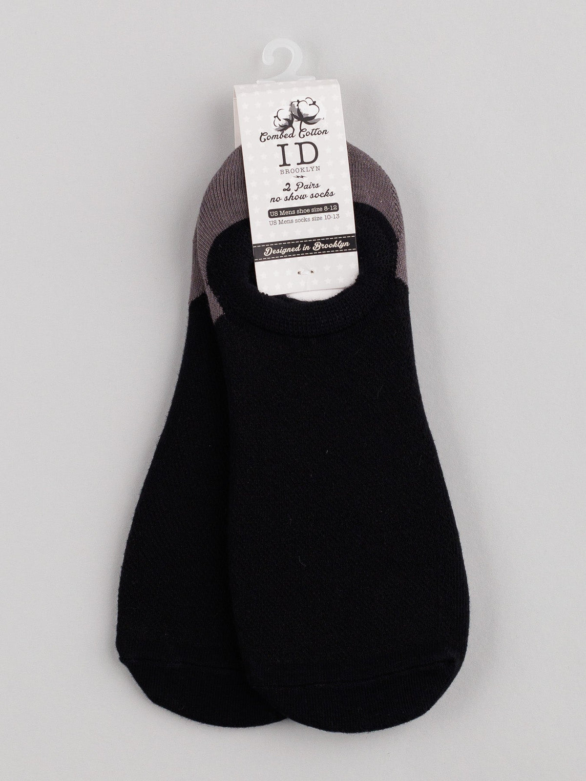 A pair of breathable, black M5 Combed Cotton no-show socks by ID Menswear is attached to a white hanger. The label displays brand and size in black text. The socks feature gray trim, arranged neatly on a gray background.