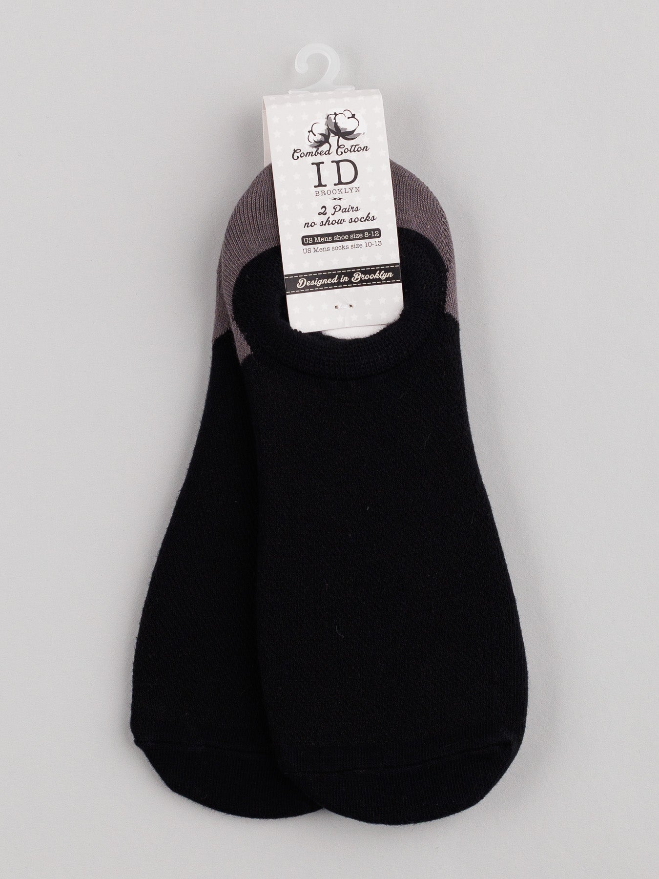 A pair of breathable, black M5 Combed Cotton no-show socks by ID Menswear is attached to a white hanger. The label displays brand and size in black text. The socks feature gray trim, arranged neatly on a gray background.