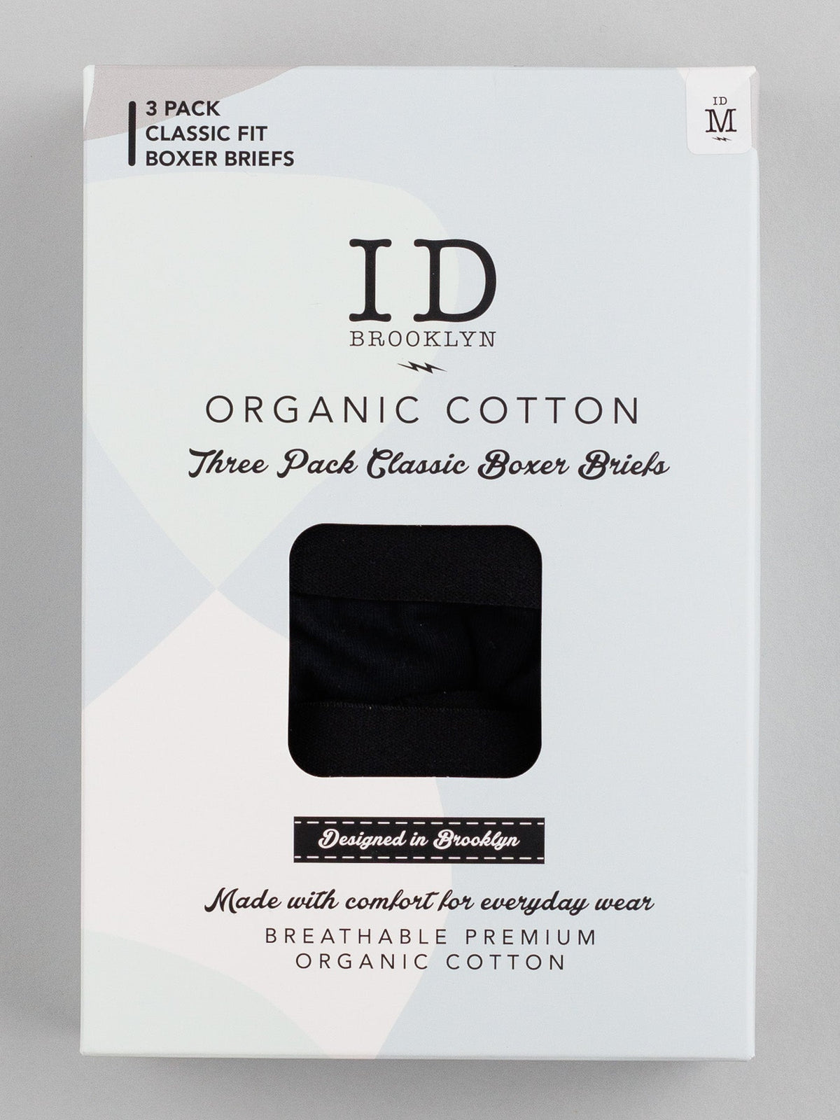 Medium-sized ID Organic Cotton Boxer Briefs 3 Pack by ID Menswear. White packaging with black text reads Three Pack Classic Boxer Briefs and Everyday Essentials designed for comfort and stretch. A small window reveals the black fabric inside.