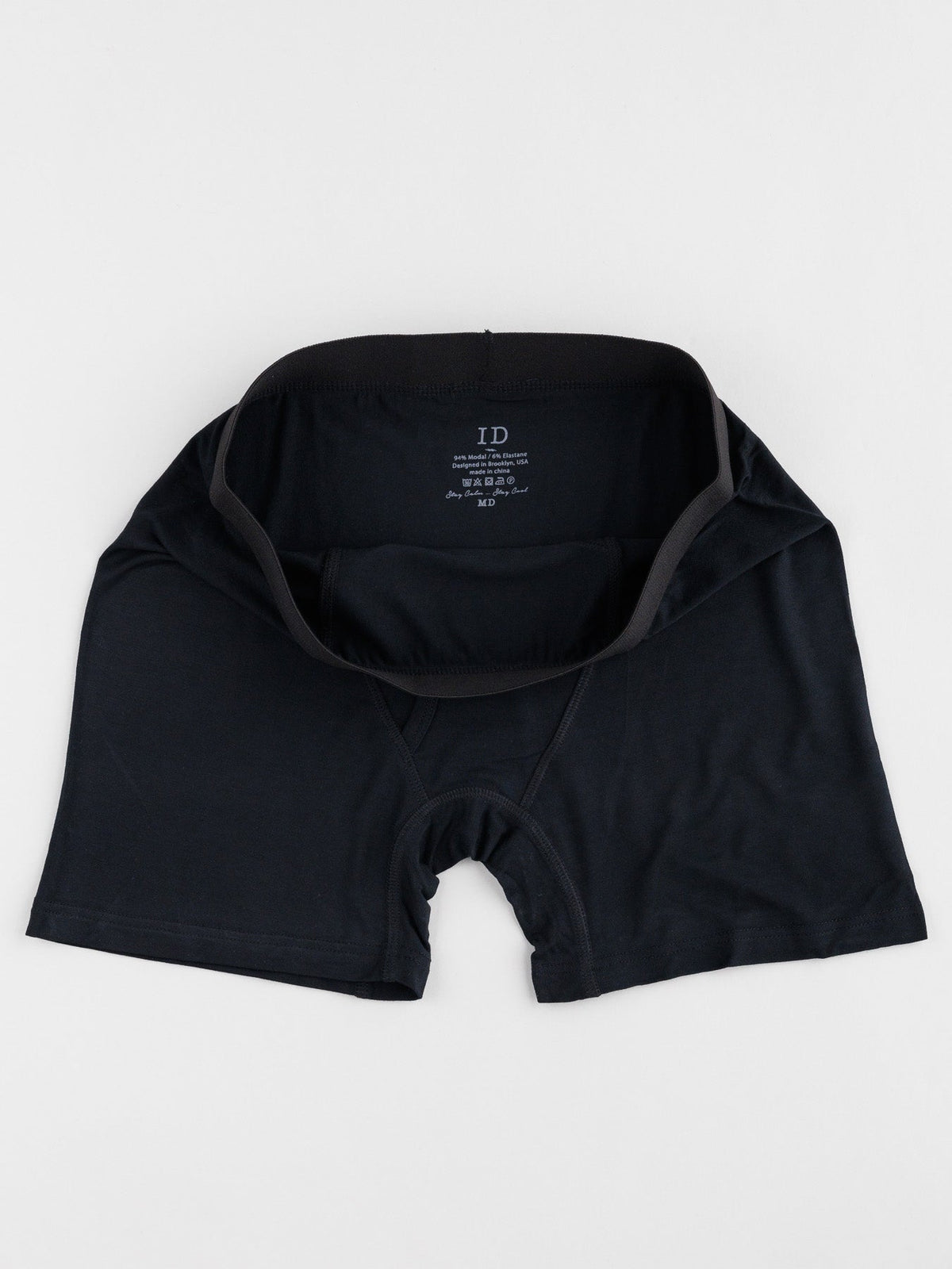 Black mens modal boxer briefs from ID Menswear are laid flat on a white surface, featuring a partially open waistband highlighting the ID Modal Boxer Briefs 3 Pack tag inside. Designed for everyday comfort, they offer just the right amount of stretch.