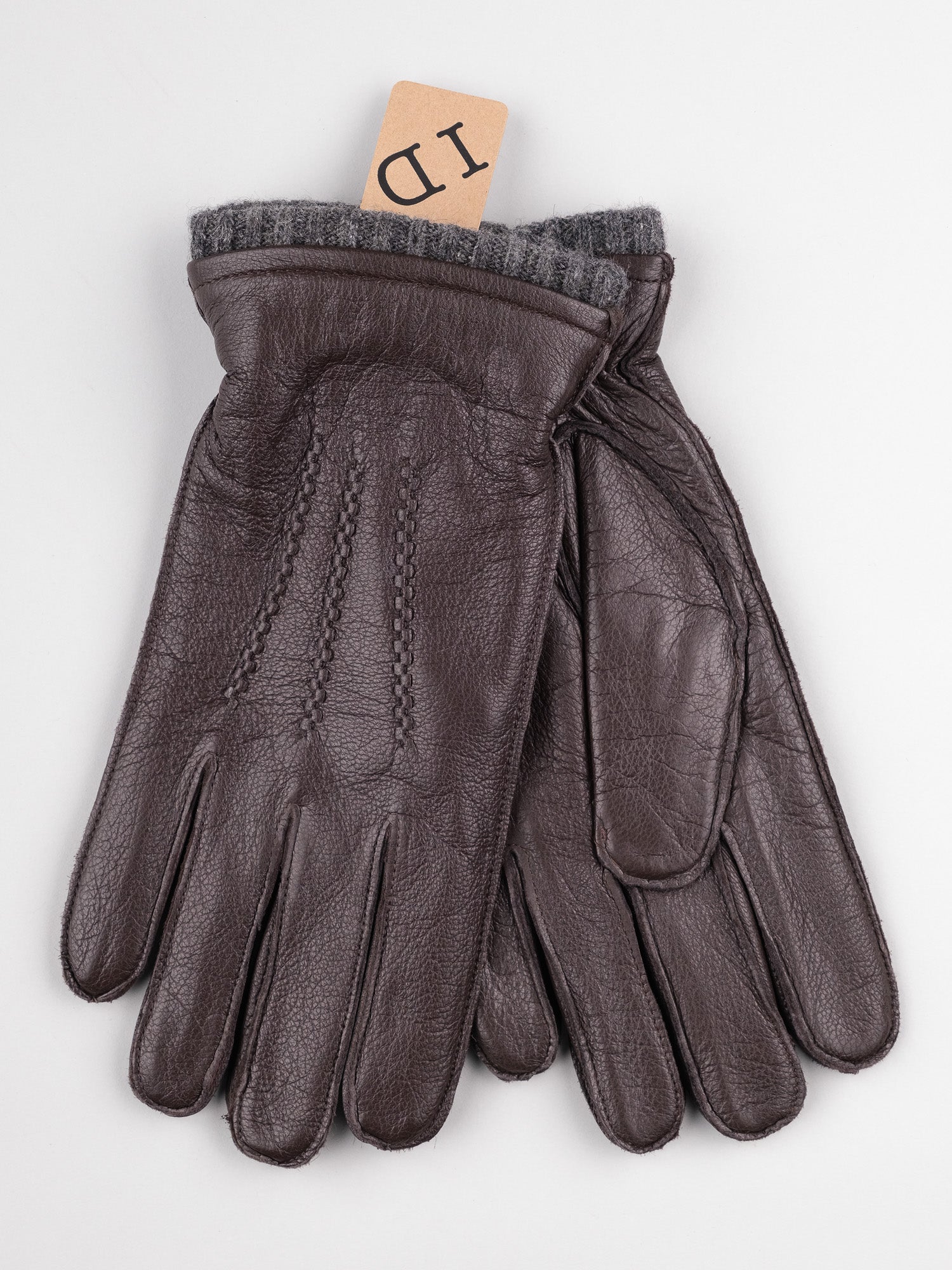 A pair of Thinsulate Lined Leather Gloves by ID Menswear in brown sheepskin leather, featuring stitched detailing and a gray ribbed wrist lining. A small beige ID tag is tucked into the right glove, offering timeless style and comfort with every wear.
