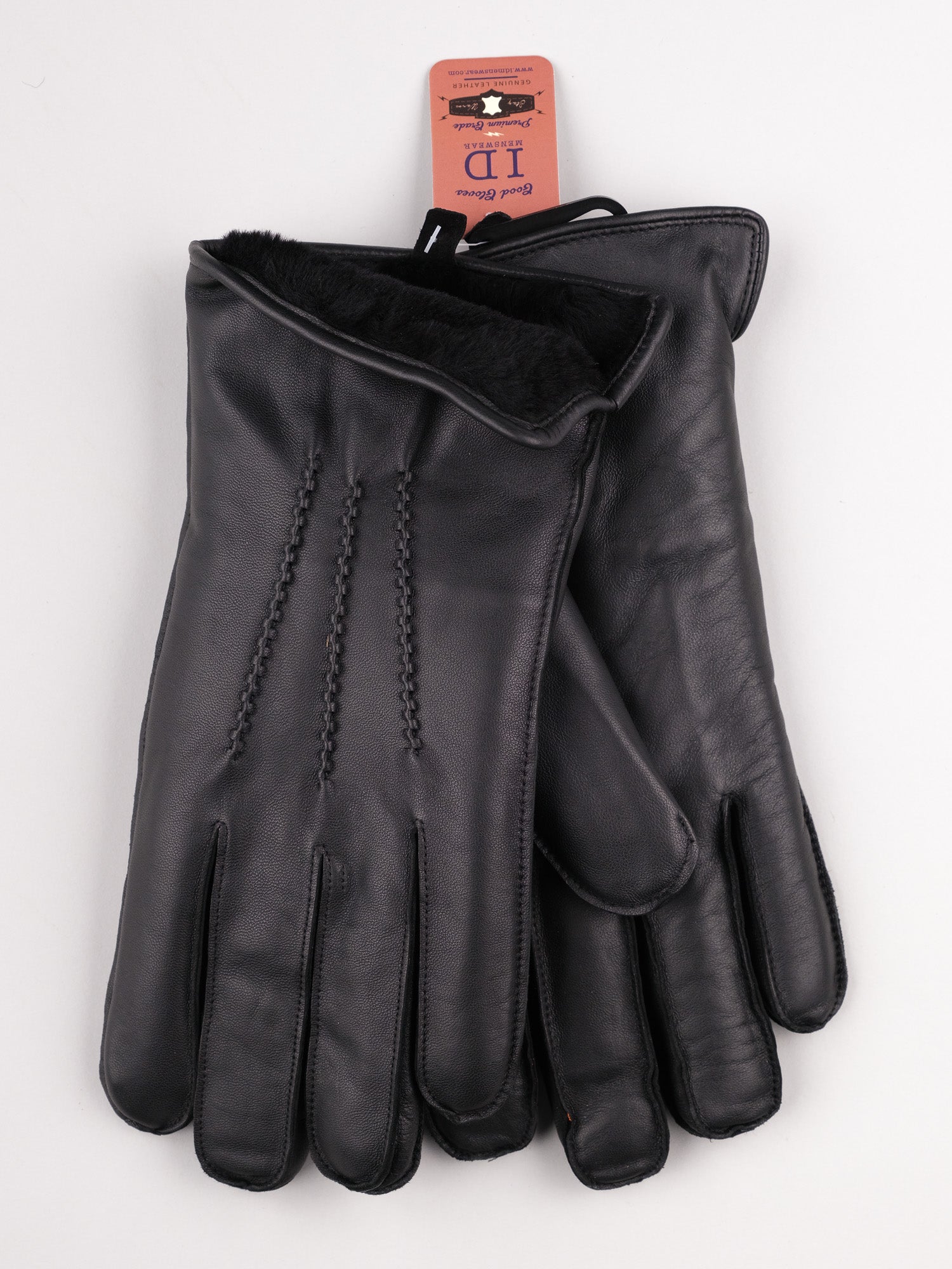 Sub Zero Shearling Lined Leather Gloves by ID Menswear lie flat, featuring decorative stitching, a visible tag, soft shearling lining at the cuffs, and touchscreen functionality.