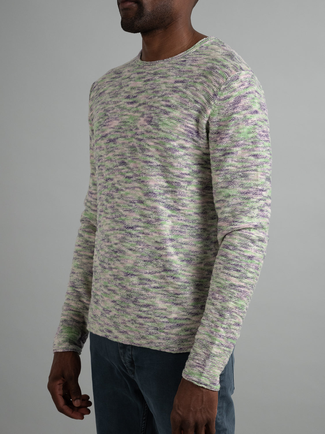 A person wearing the ID Menswear Havana Slub Yarn Sweater Tee in green, purple, and white stands against a plain background. With a round neckline and long sleeves, this casual top brilliantly complements dark pants for a premium feel.