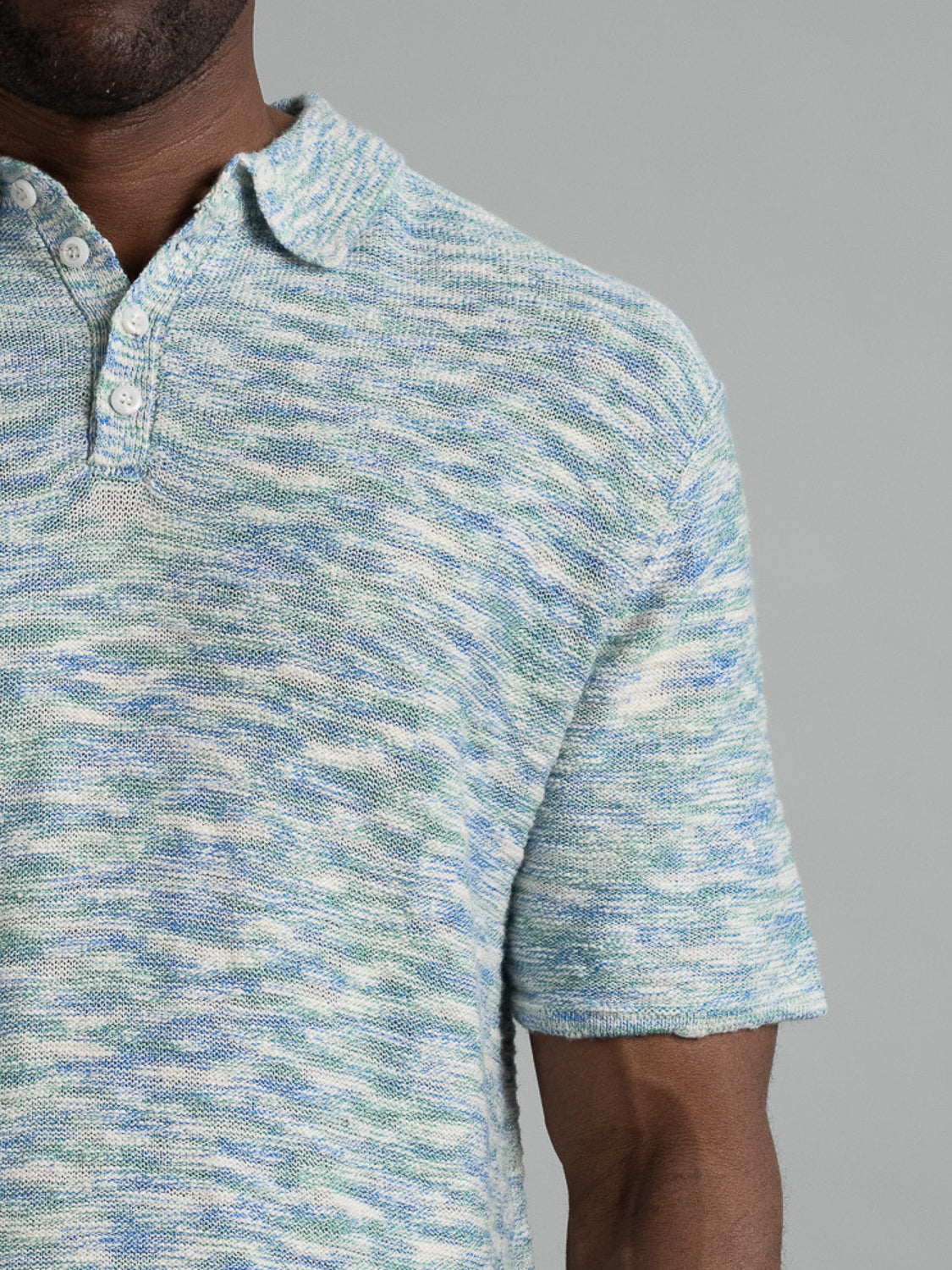 The Miami Reverse Knit Cotton Polo by ID Menswear is a textured, cotton-knit shirt in blue, green, and white. It features a buttoned collar and relaxed fit for breathable casual wear against a light gray backdrop.