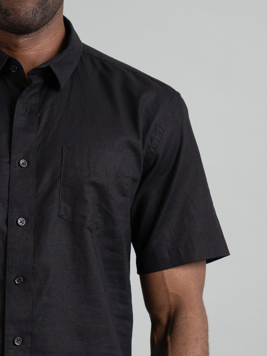 A person wears the Ravi Linen Cotton Short Sleeve Shirt by ID Menswear, showcasing its breathable linen-cotton blend and button details against a plain background. Only the upper body is visible.
