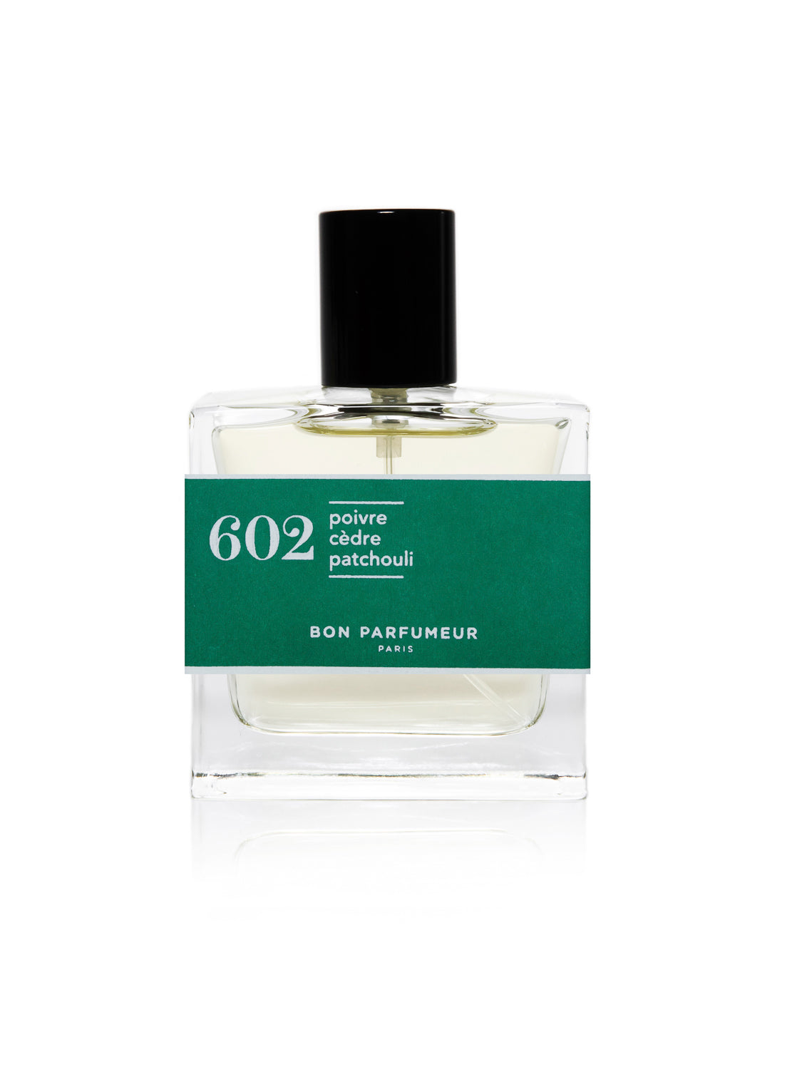 The Bon Parfumeur - 602 features a clear glass bottle with a black cap, labeled 602 poivre cèdre patchouli on a green band. Below is Bon Parfumeur Paris. Its pale yellow liquid offers an enchanting woody fragrance.
