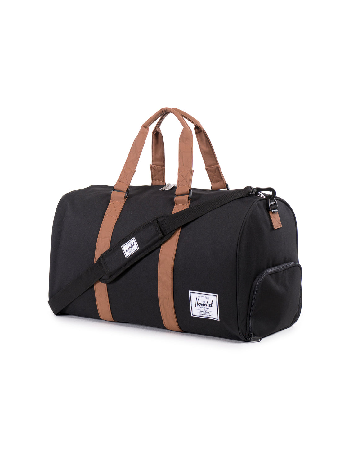 The Herschel Novel Weekender Duffle Bag is black with brown handles and strap accents, a removable shoulder strap, a white logo patch on the side, and a shoe compartment. It’s displayed on a white background.