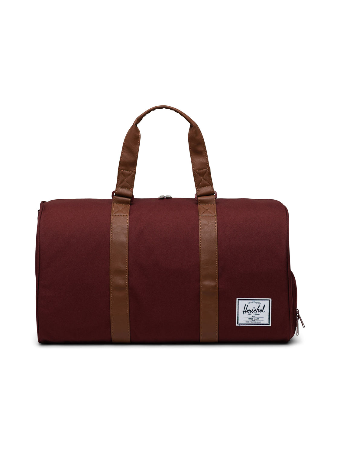 The Herschel Novel Weekender Duffle Bag in maroon has brown handles and straps, a white logo patch on one end, and a shoe compartment, displayed on a plain white background.