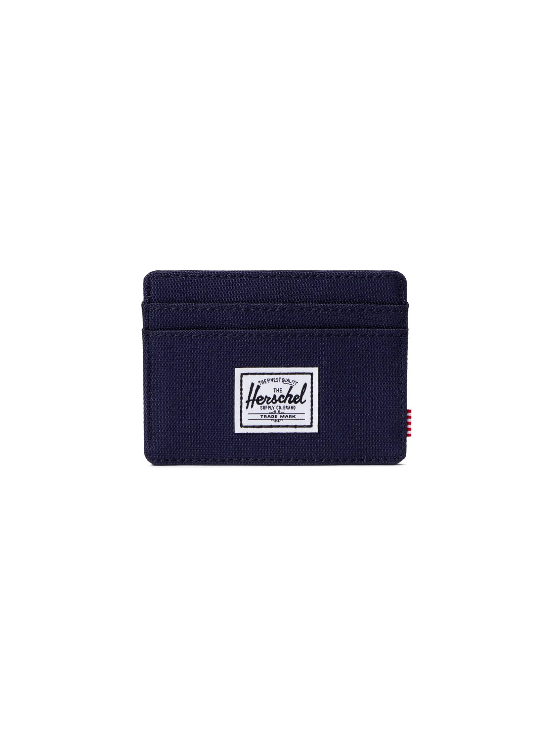 The Herschel Charlie Compact Card Holder Wallet in navy blue features RFID blocking, multiple card slots, and a white rectangular logo patch on the front, shown against a plain white background.