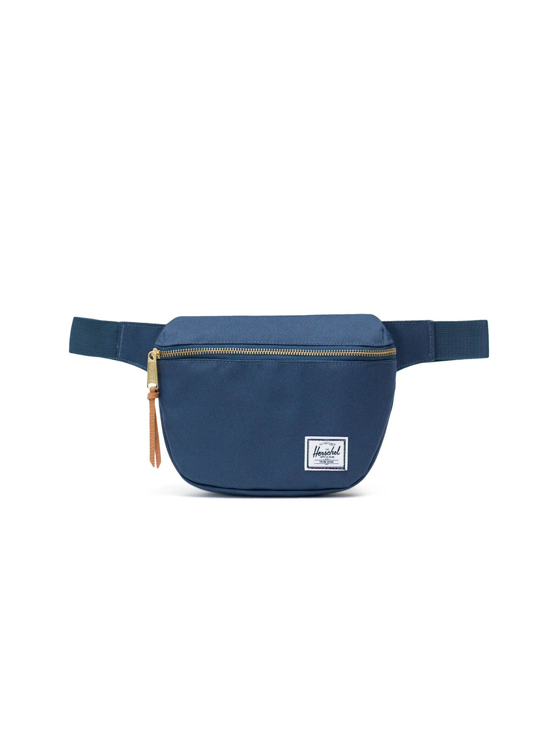 The Herschel Fifteen Hip Pack is a navy blue bag with a front metal zipper, brown leather pull, white logo patch, and an adjustable strap for comfort.