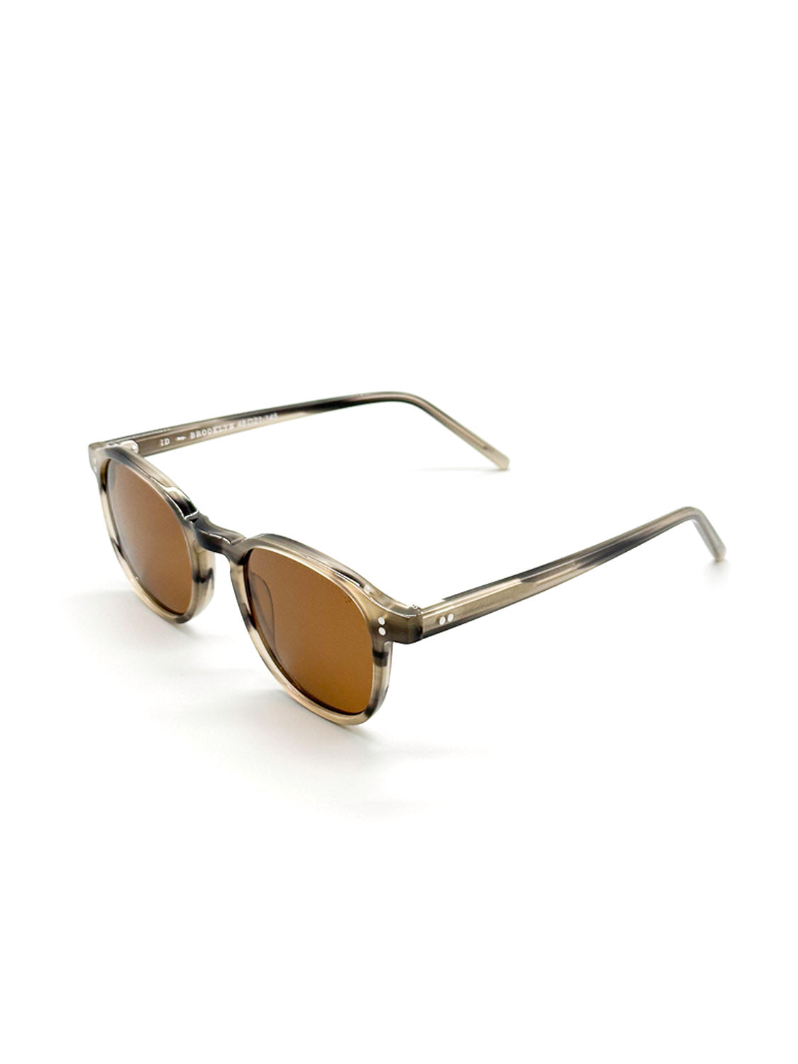 The A144C36B ID Polarized Sunglasses by ID Menswear feature round, brown-tinted CR39 polarized lenses and transparent light brown Mazzucchelli acetate frames, displayed at an angle on a white background.