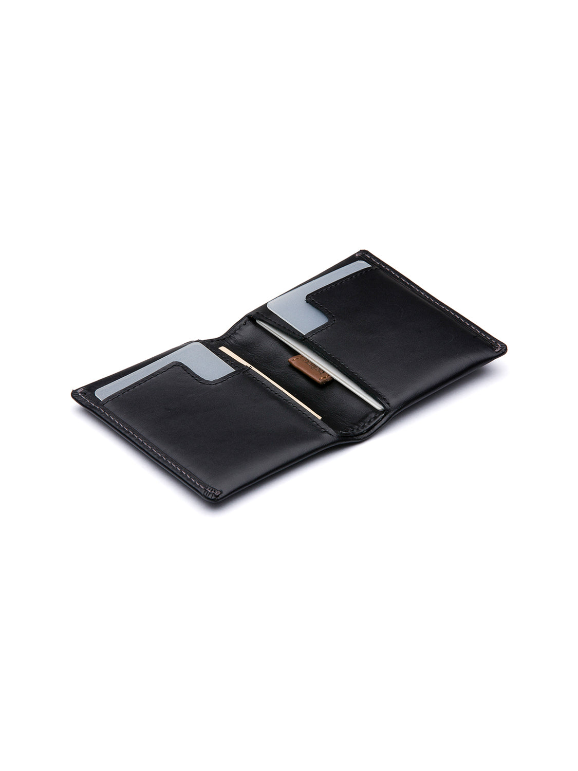 Bellroy's Slim Sleeve Wallet, in black leather, is displayed open on a white background, revealing multiple card slots, a central compartment with two gray cards, and a silver pen.