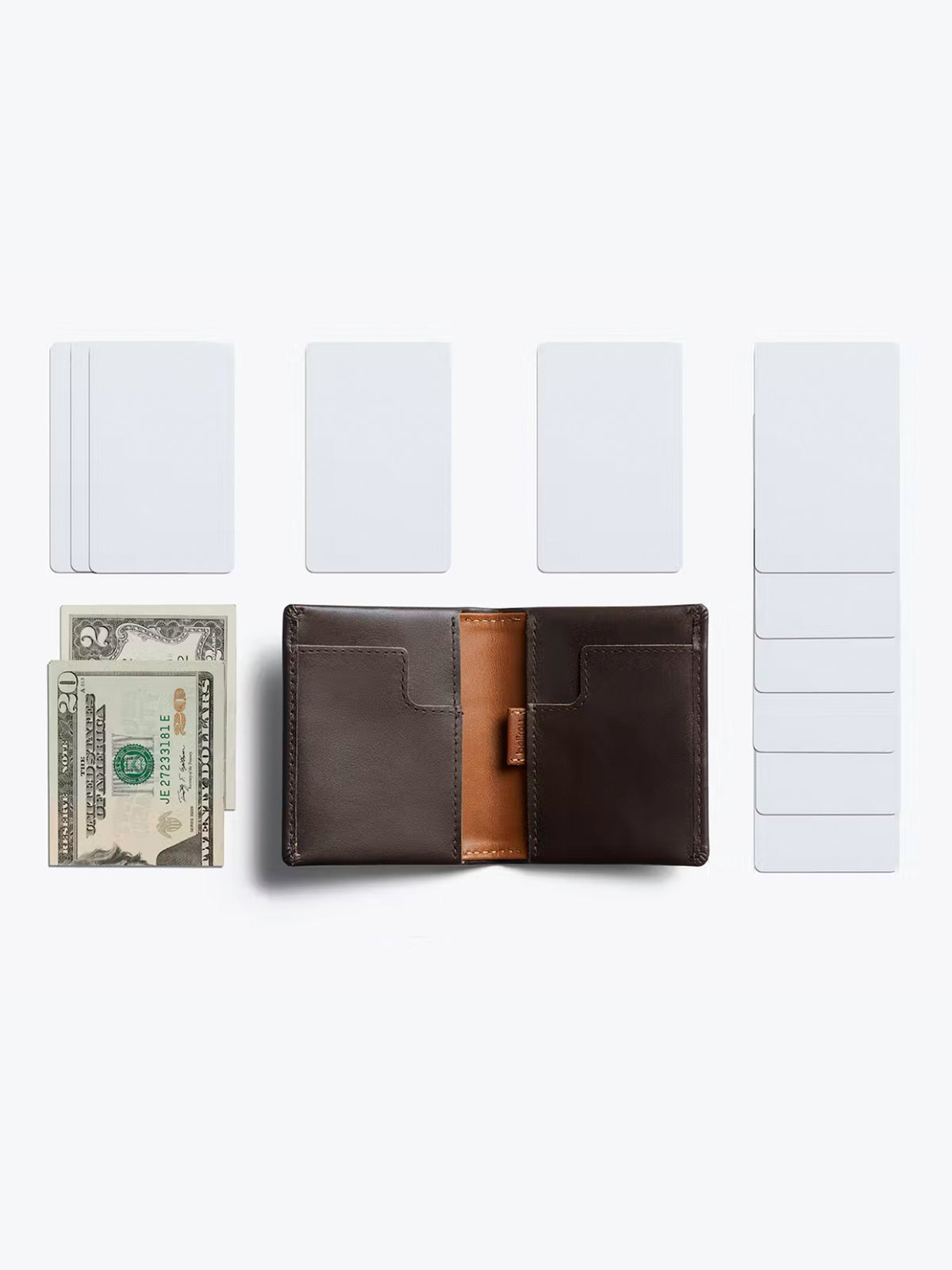 The Bellroy Slim Sleeve Wallet is open on a white background, with several blank cards and a folded twenty-dollar bill nearby, showcasing the wallet’s sleek, pocket-friendly design in a neat and organized layout.