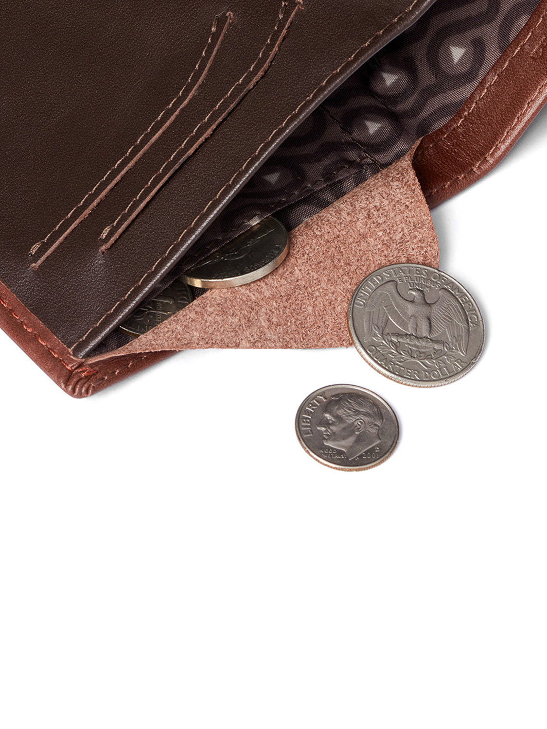 The Bellroy Note Sleeve Wallet in brown leather features a patterned lining and opens to reveal several coins inside, while a quarter and dime sit on the white surface beside this stylish slim travel billfold.