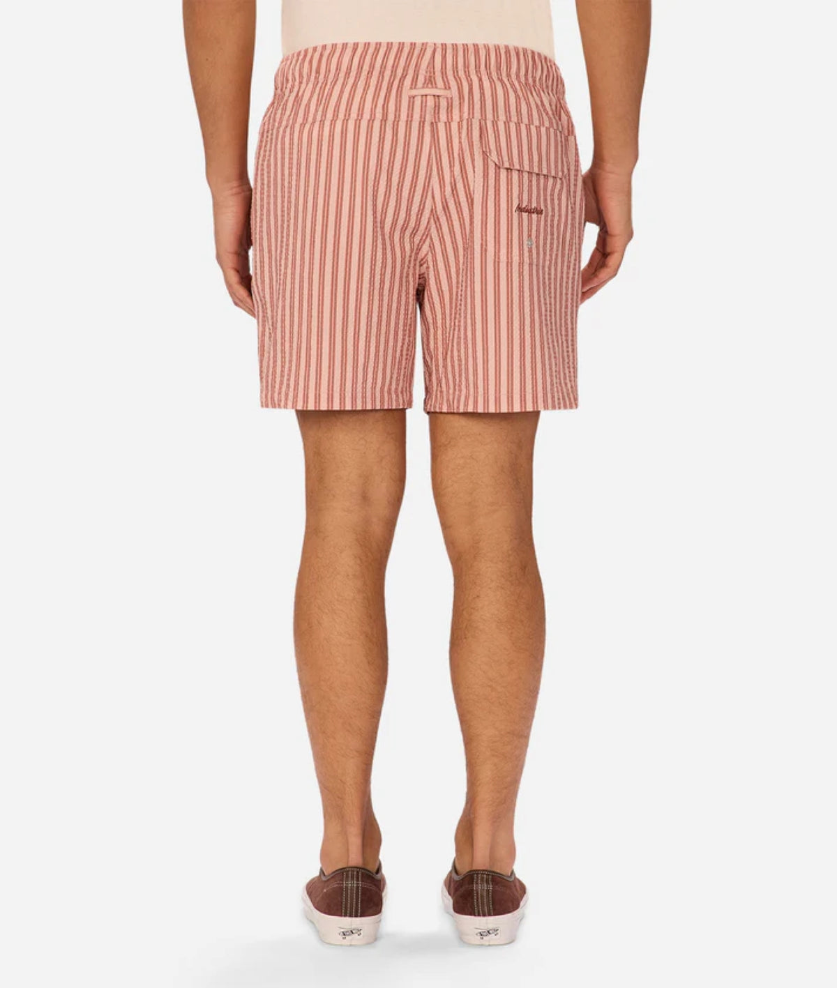 Back view of a person wearing Industrie Berkeley Swim Shorts in red and white vertical stripes with brown slip-on shoes, standing against a plain white background.