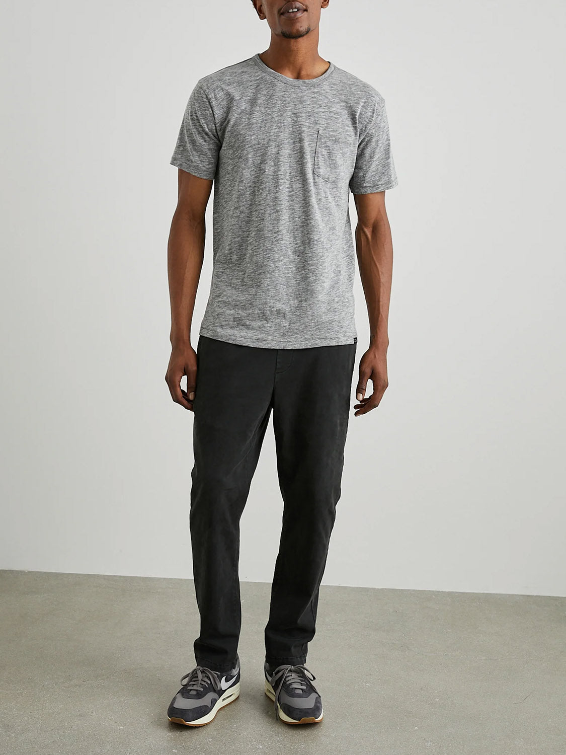 A person stands against a white background, wearing the Rails Skipper Tee in super soft gray cotton, dark pants, and sneakers. Positioned facing forward, the floor is light gray.