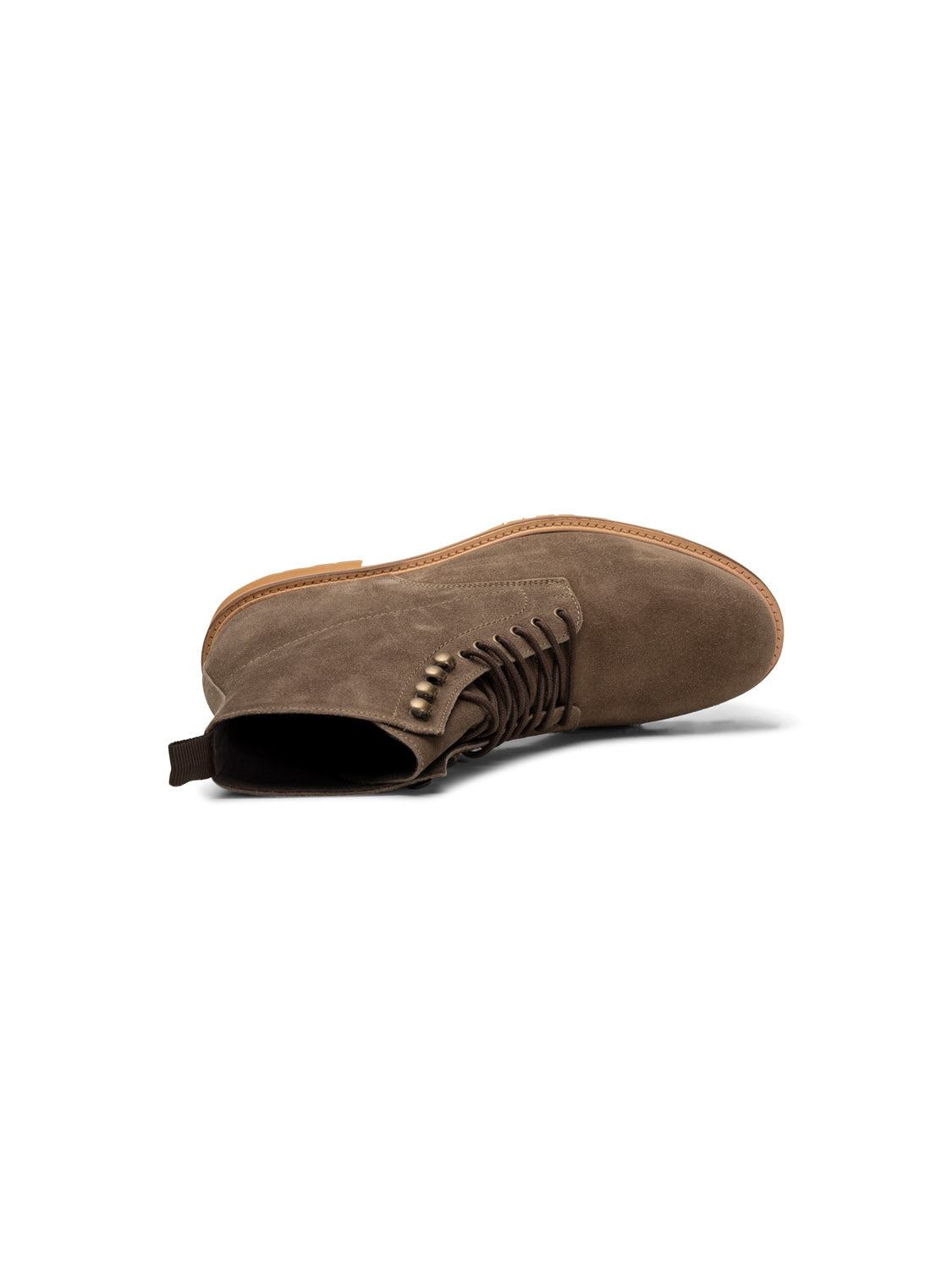 The York Suede Lace Up Boot by Shoe The Bear, resting on its side against a white background, showcases handcrafted brown suede with decorative stitching, metal eyelets, a light brown sole, a pull tab at the heel, and is made from LWG-certified materials.