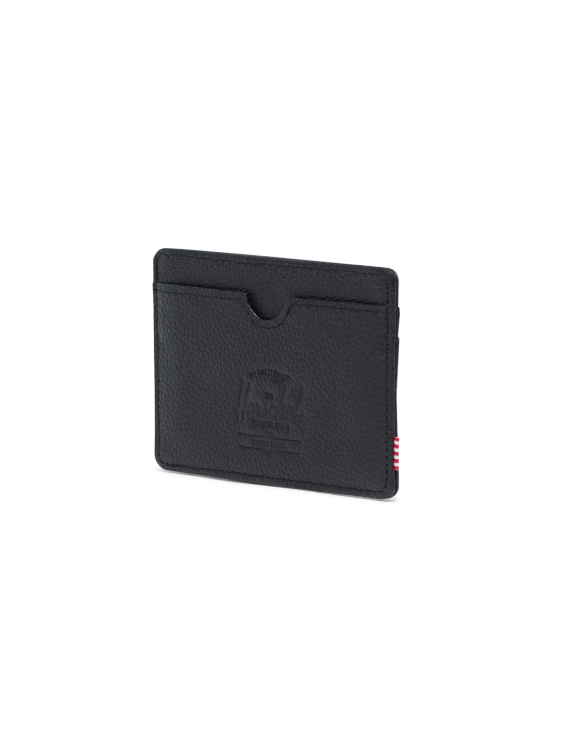 The Herschel Charlie Leather Card Holder Wallet is a compact black textured leather wallet with RFID blocking, an embossed front logo, one card slot, and a small red and white side tag.