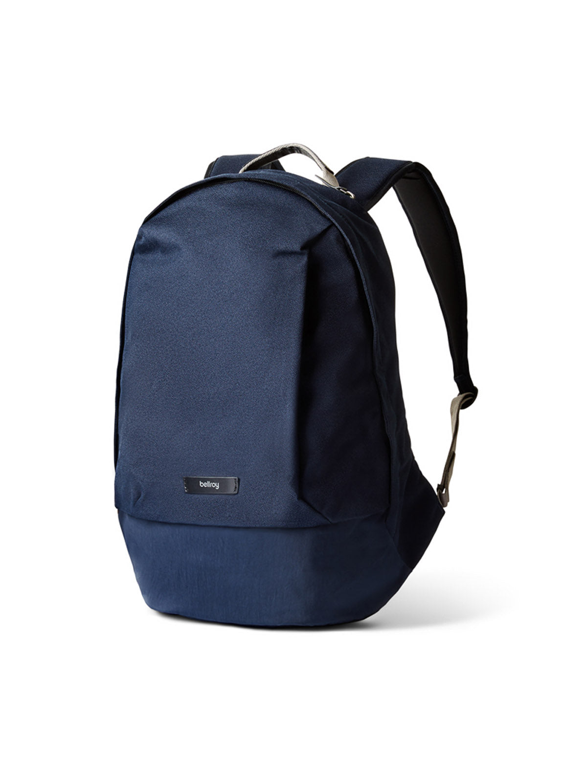 The Bellroy Classic Backpack - 20L in navy blue, made from recycled materials, features a front zip pocket and black shoulder straps, shown standing upright against a white background.