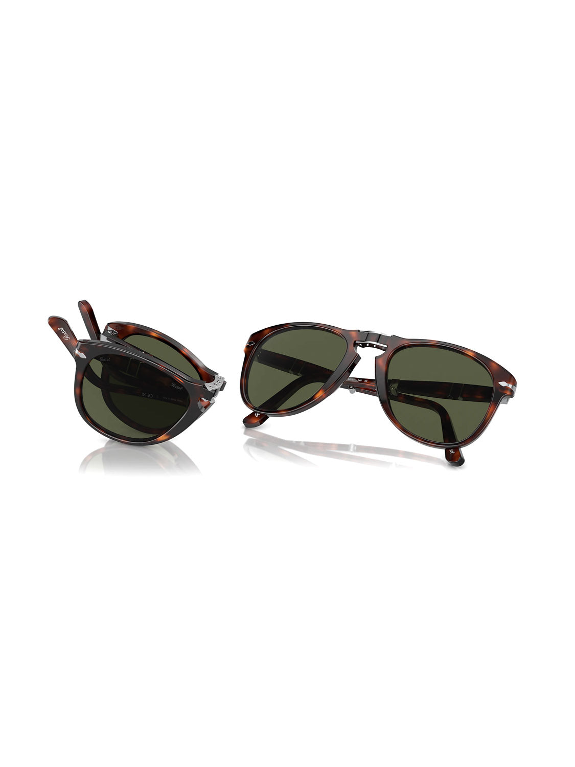The Persol - PO714 sunglasses feature dark lenses with elegant tortoiseshell acetate frames. One pair uses folding technology and is neatly folded, while the other remains open, both elegantly displayed on a reflective white surface.