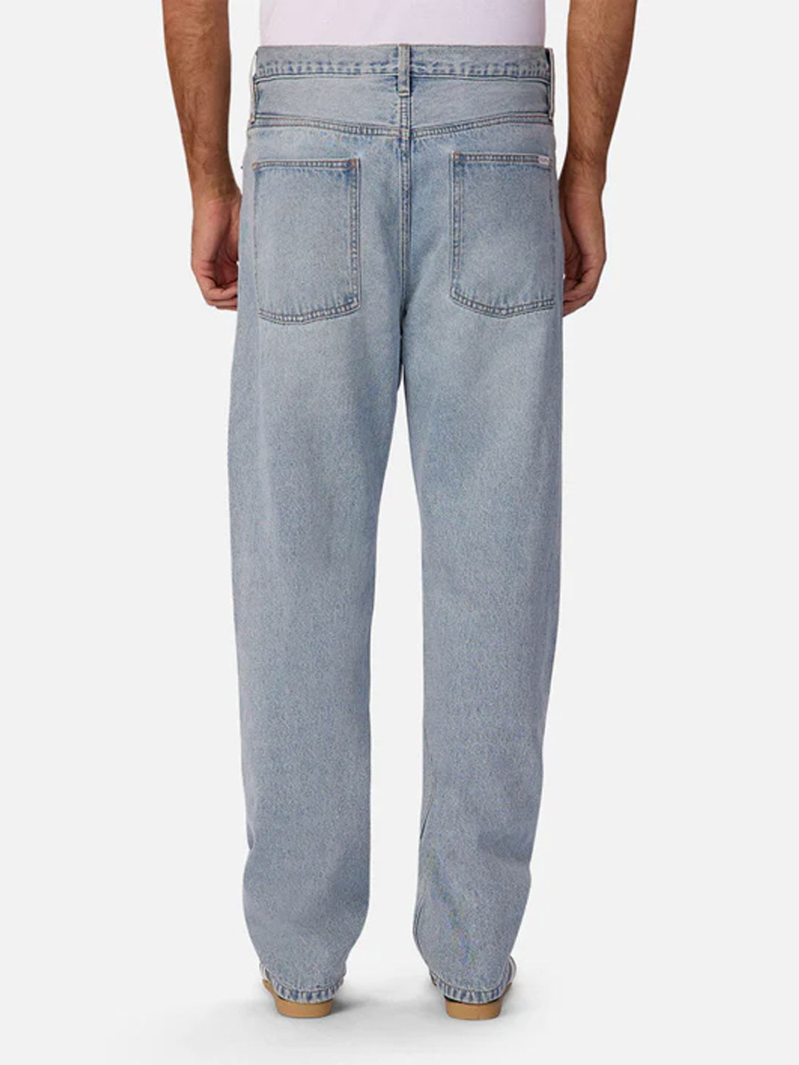A person wearing Industrie’s 90s Jean Stone Wash, seen from the back against a plain white background. The jeans feature two back pockets and a relaxed, straight-leg fit with a vintage-inspired wash.