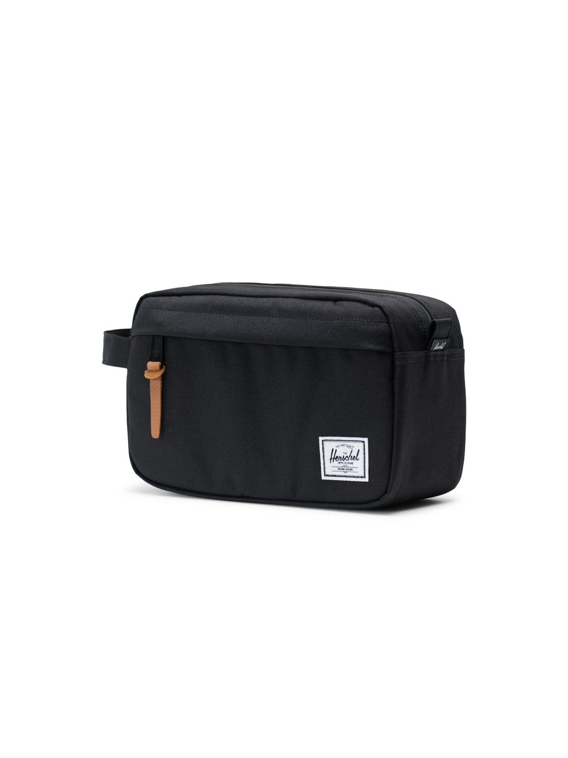 The Herschel Chapter Travel Kit is a black rectangular toiletry organizer with a side handle, a waterproof-zippered front pocket with a tan pull tab, and a white Herschel label on the lower right, all shown on a white background.