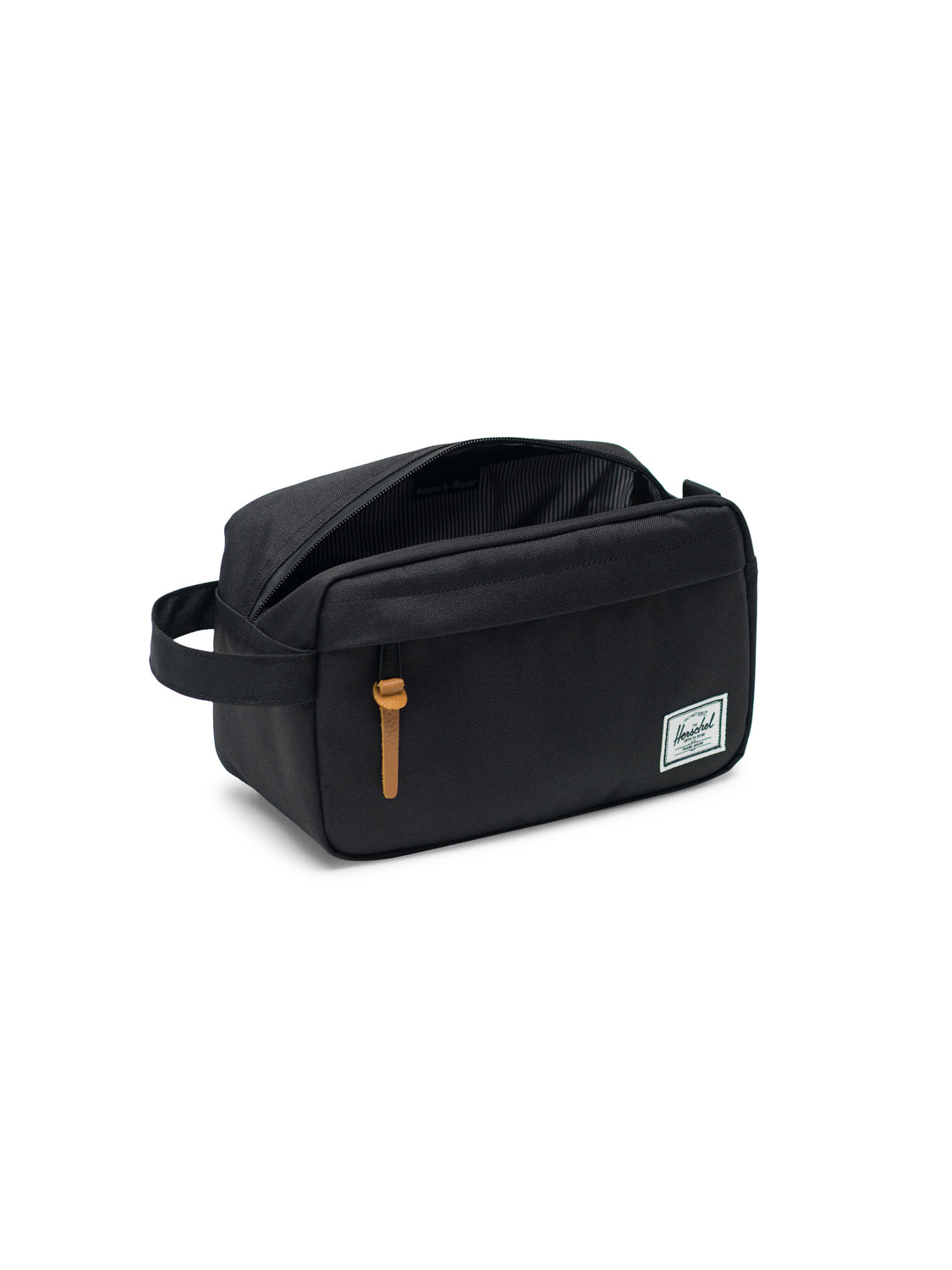The Herschel Chapter Travel Kit is a black rectangular organizer with a side handle, front zipper pocket with leather pull, and white branded label. Its main compartment features a striped lining—ideal for stylish travel storage.